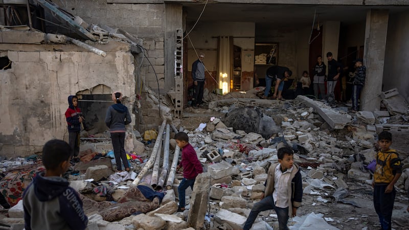 Palestinians look at the destruction after an Israeli strike in Rafah, southern Gaza Strip,...