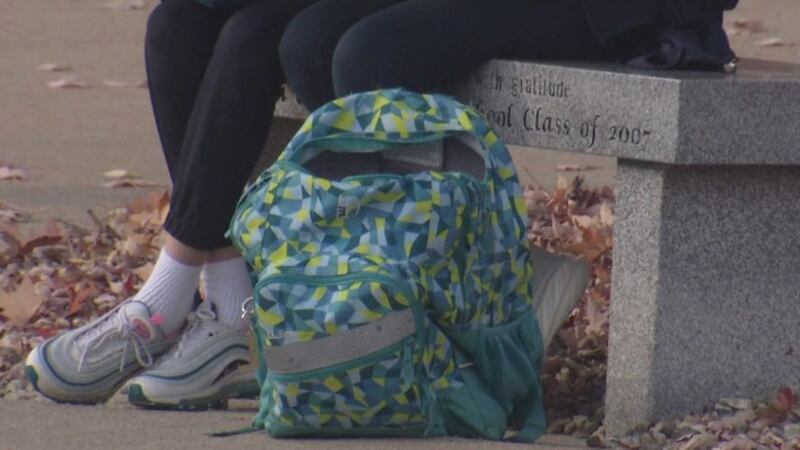 Holy Family Catholic Schools students sit with a backpack.